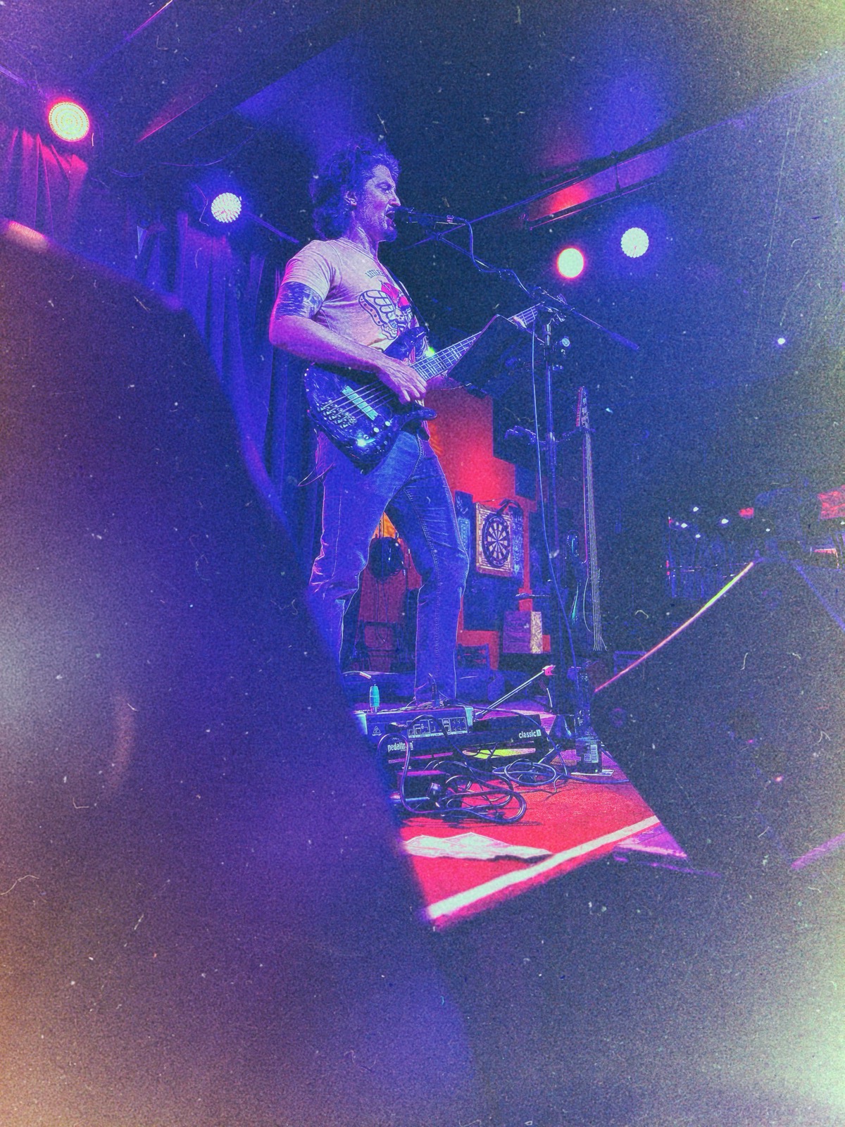 Stephen McQuay playing bass live, stage lighting